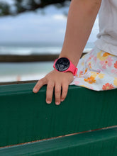 Load image into Gallery viewer, Person wearing a pink Pjama Vibrating on a green bench outdoors.