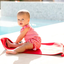 Load image into Gallery viewer, Baby in pink outfit sitting on a red mat by a pool