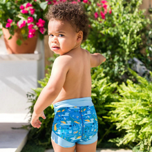 Load image into Gallery viewer, Child wearing blue swim shorts with a pattern outdoors
